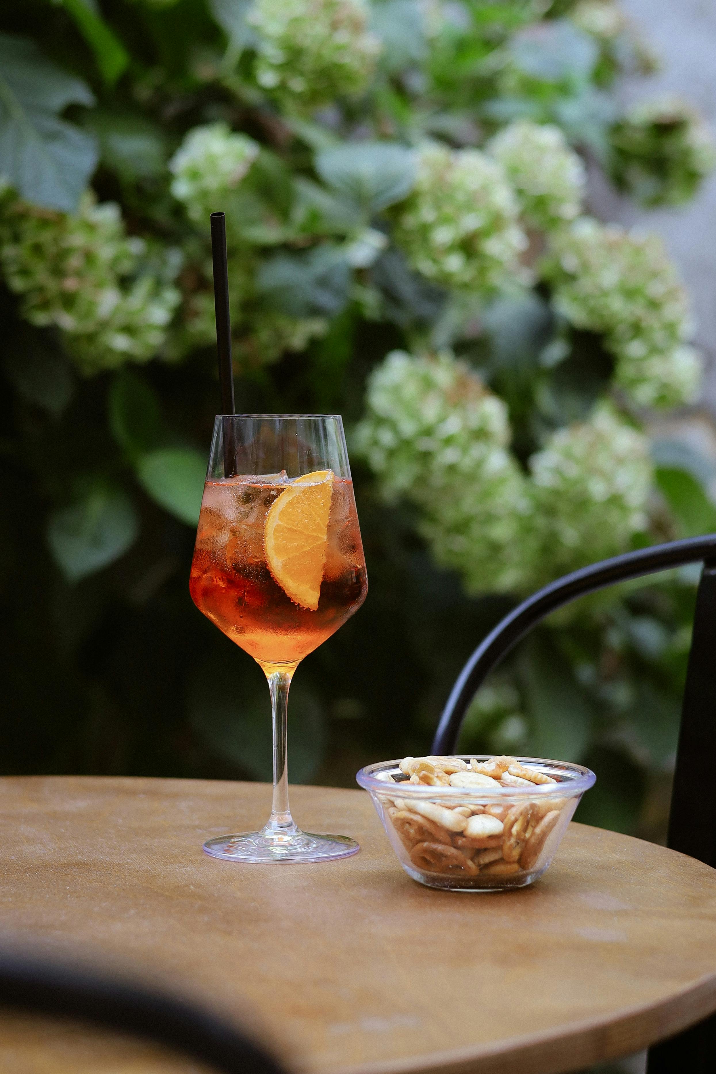 Aperol Spritz on a terrace table with snacks