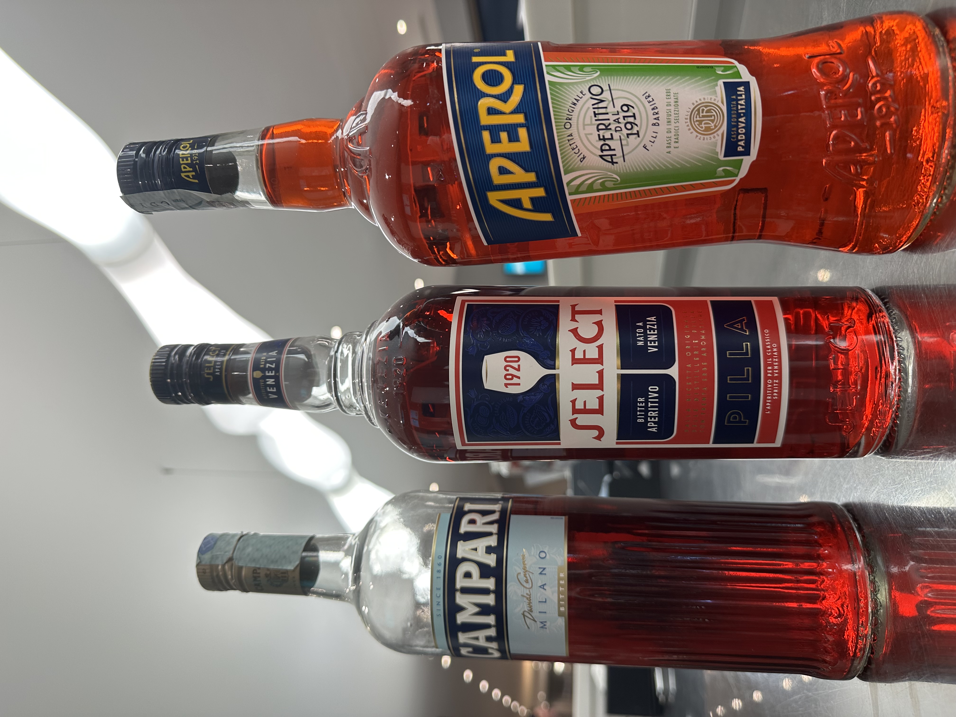 Campari, Select, and Aperol bottles side by side
